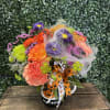 Halloween bouquet in a pumpkin mug with orange, purple, and pink flowers