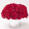 Red roses arranged in a clear glass vase