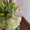 Pink tulips arranged with white hydrangeas in a glass vase