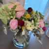 Mixed bouquet in a clear glass vase with pink, white, and yellow blooms