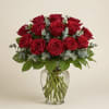 Red roses arranged in a clear glass vase