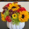Sunflowers and mixed chrysanthemums arranged in a white pumpkin vase