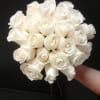 Bouquet of white roses held against a dark background