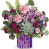 Mixed pink and purple bouquet in a patterned vase with a succulent centerpiece
