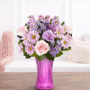 Pink and lavender mixed bouquet in a tall purple vase