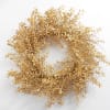 Dried golden wreath with small clustered leaves on a white background