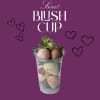Chocolate-dipped strawberries in a clear cup with decorative hearts