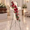 Standing cross-shaped floral tribute with red roses and white flowers