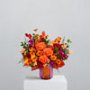 Orange and red mixed bouquet in a striped glass vase