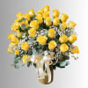 Yellow roses arranged in a gold vase with white baby's breath and a ribbon bow
