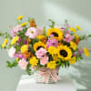Mixed bouquet in a white basket with a striped ribbon