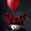Red rose arrangement in a white painted vase with a red balloon above it