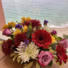 Mixed bouquet of red, pink, yellow, and white flowers on a table