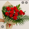 Bouquet of red roses wrapped in burlap with palm leaves