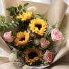 Bouquet of sunflowers and pink roses wrapped in beige paper