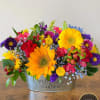 Low galvanized tin arrangement of bright sunflowers, red roses, and mixed colorful blooms