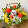 Basket arrangement of orange roses and yellow and white daisies with a small white teddy bear in the center