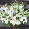 Large basket of white orchids, roses, hydrangeas and calla lilies with soft peach accents.