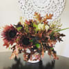 Autumn bouquet with dark sunflowers in a white vase