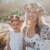 Woman and child wearing floral crowns and white dresses outdoors