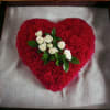 Heart-shaped red floral arrangement with white roses in the center
