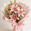 Pink lilies open wide above soft pink roses in this romantic bouquet-an