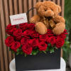 A compact cluster of vivid red roses set against a matte black