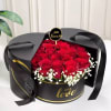 Red roses in a black round gift box with white baby's breath