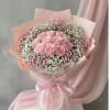 Pink rose bouquet wrapped in pastel paper with a ribbon