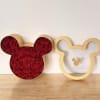 Red roses arranged in a Mickey Mouse-shaped box beside an empty matching frame