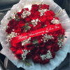Deep, velvety red roses clustered tight against clouds of white baby's breath