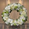 White and green floral wreath on a gold stand