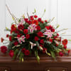 Large red and pink floral spray on a casket