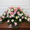 Pink and white floral casket spray with roses and daisies