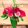 Pink roses and lilies arranged in a clear glass vase