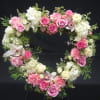 Heart-shaped floral wreath with pink and white roses and hydrangeas