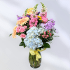 Colorful mixed bouquet in a glass vase with a yellow ribbon