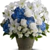 Blue hydrangeas and white lilies with roses in a gray vase