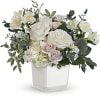 White floral arrangement in a clear square vase