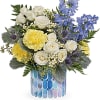 Bouquet of white roses, yellow blooms, and blue flowers in a mosaic vase