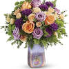 Bouquet of peach, lavender, and purple roses in a tall iridescent vase