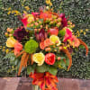 A traditional autumn floral arrangement in a glass vase consisting of various