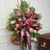 Standing floral spray with pink and red roses and a ribbon bow