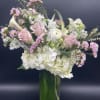 Tall vase arrangement with white hydrangeas, pink roses, calla lilies, and mixed white and pink blooms