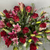 Bouquet of red roses and pink lilies with greenery