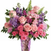 Overflowing with soft pink roses, delicate lavender stock, vibrant alstroemeria, and textured