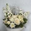 White floral arrangement with a clear cross centerpiece in a white pedestal vase