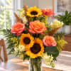 Sunflower and rose bouquet in a clear glass vase