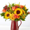 Sunflower and orange rose bouquet in a red pitcher vase