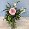 Pink gerbera daisy arrangement in a clear glass vase with white blooms